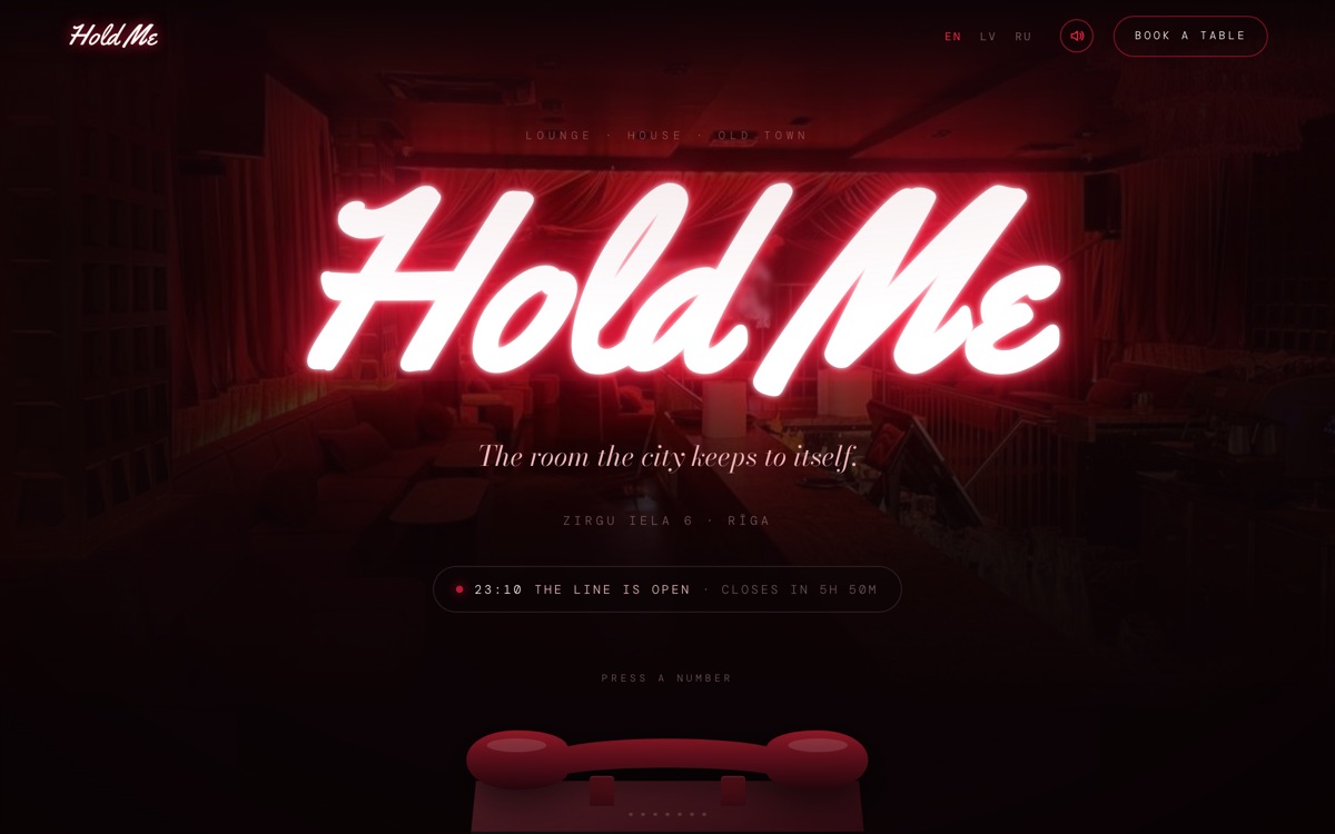 Сайт бара и клуба Hold Me на экране компьютера с меню и часами работы